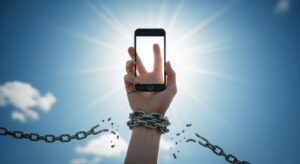 青空の下、手錠を断ち切ってスマートフォンを掲げる手の写真。象徴的な構図で、「スマホ料金の高すぎる構造からの解放」や「通信の自由」「支配からの脱却」といったテーマ性を強く表現している。